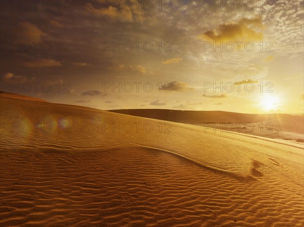 White sand dunes on sunrise, Mui Ne, Vietnam. With lens flare and light leak