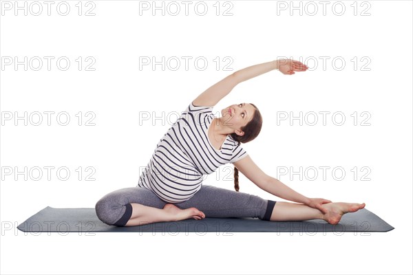 Pregnancy yoga exercise, pregnant woman doing asana Parivrtta janu sirsasana head to knee pose
