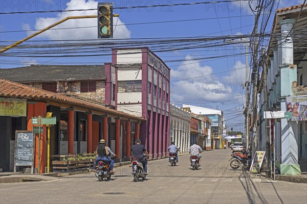 Streetscene showing Bolivians on motorcycles in the colonial city centre of Trinidad in the Amazon,