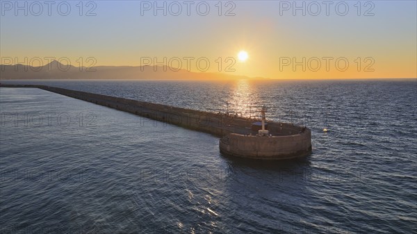 Evening light, sunset, harbour light, harbour wall, mountains, blue and orange sky, harbour,