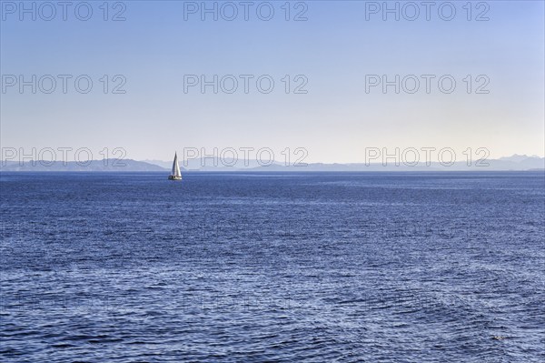 Strait, Strait of Bonifacio, sailboat in front of Sardinia Island on horizon, blue sky,