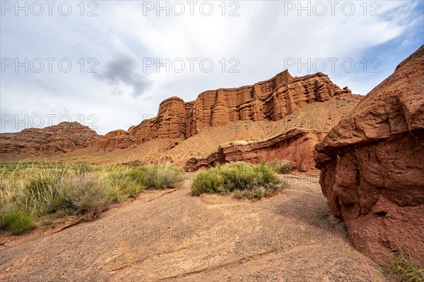 Eroded mountain landscape with sandstone cliffs, red and orange rock formations, Konorchek Canyon,