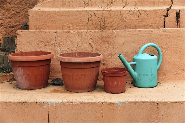 Empty flower pots with watering can on a wall, terrace, lost place, Spain, Europe