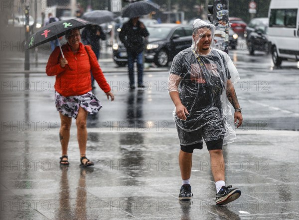 Tourists with rain capes and umbrellas during heavy rainfall, Berlin, 23 06 2023