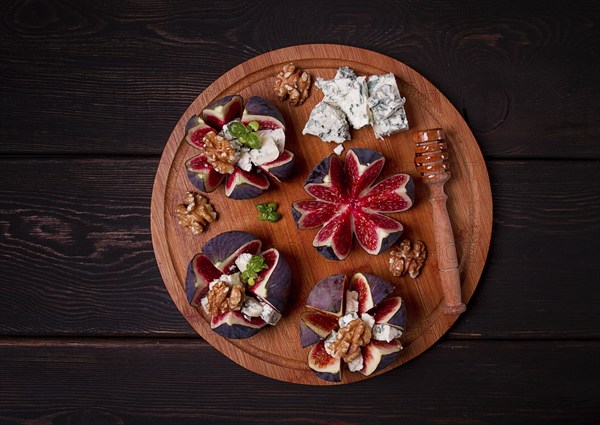 Appetizer, Figs with blue cheese, walnut, honey, on a wooden board, top view, close-up, no people