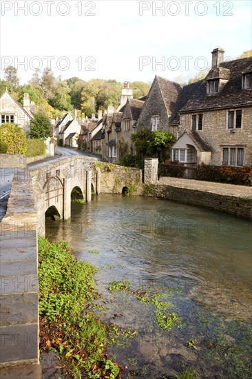 Bybrook River running past stone cottages in Castle Combe, Wiltshire, England, UK claimed to be