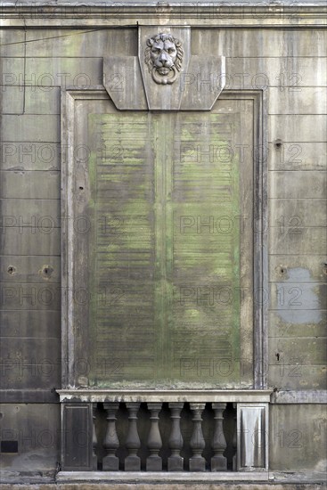 Lion's head above an emission-soiled window of an abandoned palazzo, historic centre, Genoa, Italy,