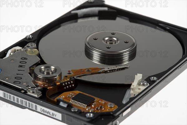 Computer hard drive, opened, read/write head on the storage disc. Symbol image