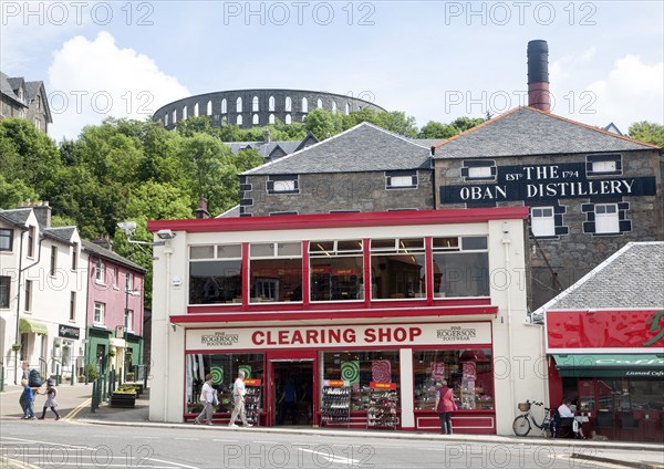 Distillery and shops Oban, Argyll and Bute, Scotland, UK with McCaig's Tower in the background
