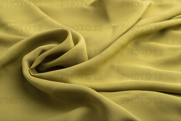 Fragment of green olive silk tissue. Side view, natural textile background and texture. wave