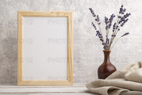 White wooden frame mockup with lavender in ceramic vase and linen textile on gray concrete