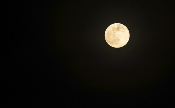 Full moon shortly after moonrise in a black night sky, Lower Saxony, Germany, Europe