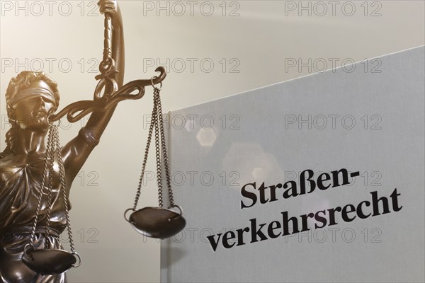Symbolic image: Textbook on traffic law and a Justitia