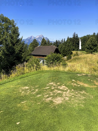 Golf Course with Mountain View and Peak Pilatus and the Moon in a Sunny Summer Day in Burgenstock,