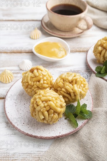 Traditional Tatar candy chak-chak made of dough and honey with cup of coffee on a white wooden