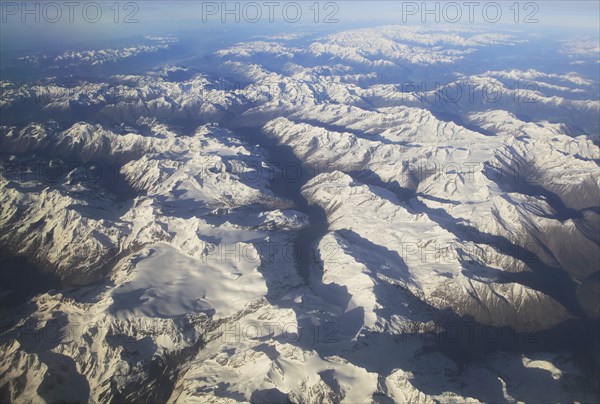 View from plane of snow covered mountain peaks in the Alps between France and Italy
