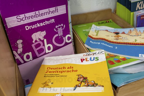 Classroom of a fourth grade, after school, the building is older but in good condition, textbooks,
