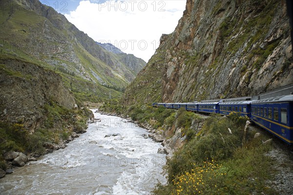 Perurail train travelling through the Andes from Ollantaytambo to Machu Picchu, in front the river