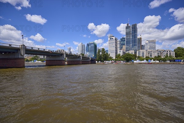 Untermainbrücke, Main river and skyscrapers under blue sky with cumulus clouds in Frankfurt am
