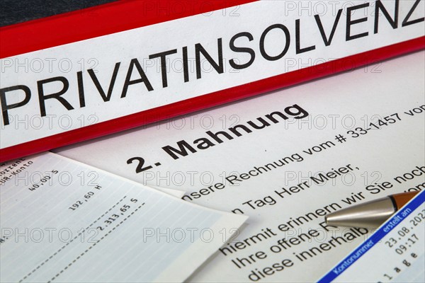Symbolic image of personal insolvency: folder, bank statement and a reminder