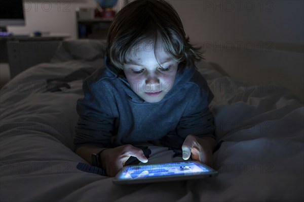 A boy plays computer games on a tablet PC