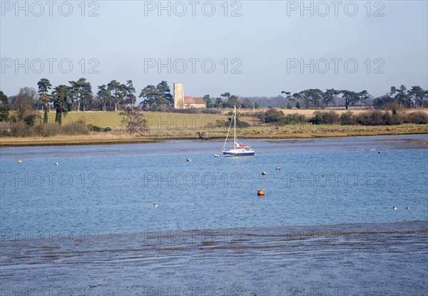Ramsholt church and moored yacht seen from across River Deben, near Kirton Creek, Suffolk, England,