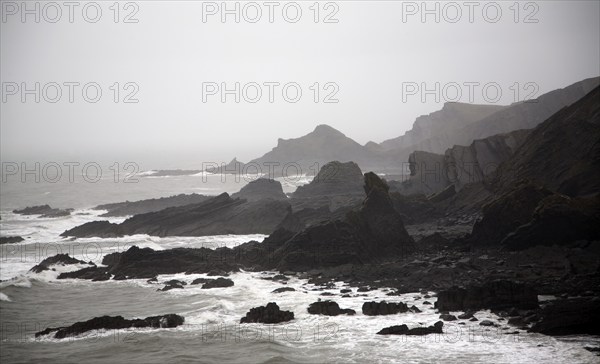 Large Atlantic storm waves crashing onto jagged rocky coast at Hartland Quay, north Devon, England,