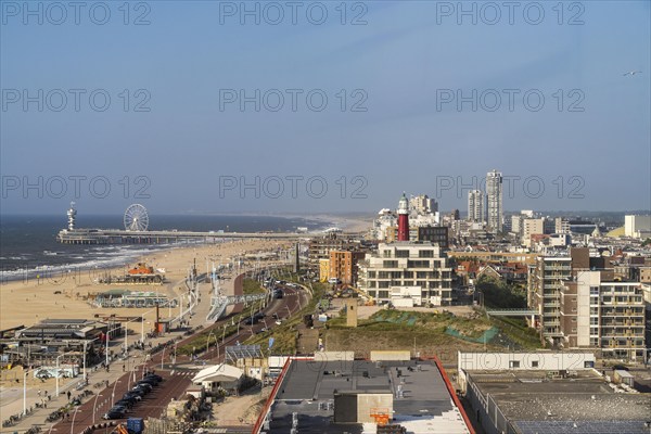 View over the beach of Scheveningen, the pier with Ferris wheel and the skyline of the town, which