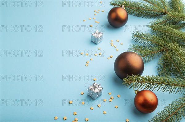 Christmas or New Year composition. Decorations, bronze balls, fir and spruce branches, on a blue