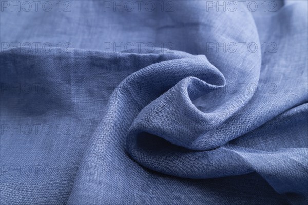 Fragment of blue linen tissue. Side view, natural textile background and texture. wave concept,