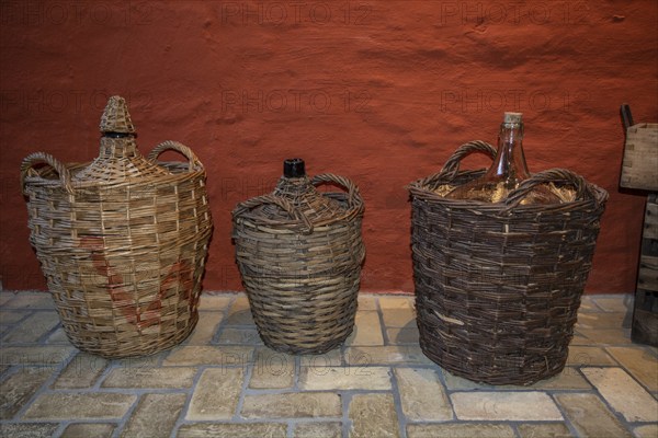 Old basket bottles for storing rum in the rum museum in Flensburg, Schleswig-Holstein, Germany,