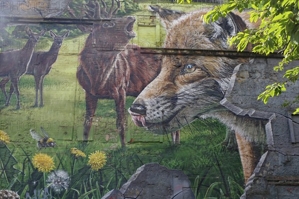 Vibrant mural depicting a fox, deer and a green meadow with flowers and trees, Mural Trail,