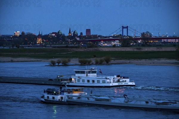 Cargo ship on the Rhine near Duisburg-Beeckerwerth, skyline of the city centre, with town hall,