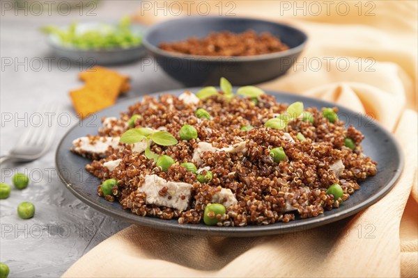 Quinoa porridge with green pea and chicken on ceramic plate on a gray concrete background and