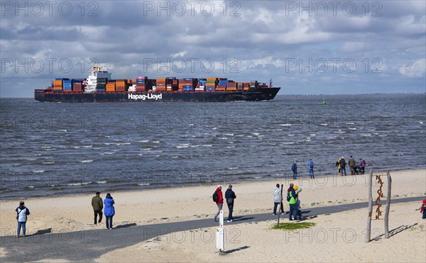 Beach promenade with container ship in the district of Döse, North Sea spa town of Cuxhaven, North