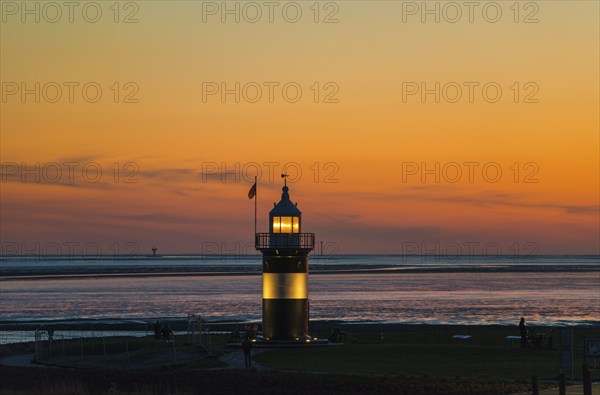 Black and white lighthouse, called 'Kleiner Preuße', stands on the coast in front of an