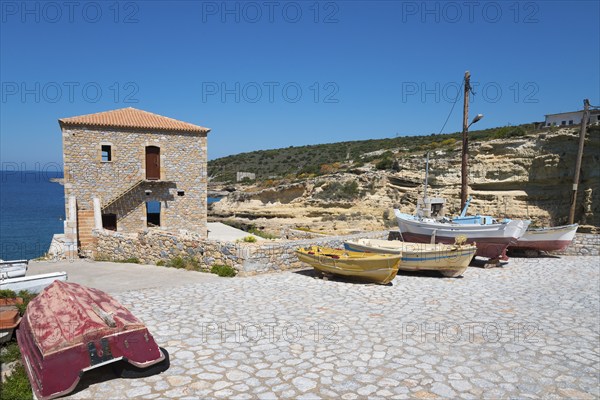 Small harbour with fishing boats and stone house on a rocky coast, Mezapos, Mani, Peloponnese,