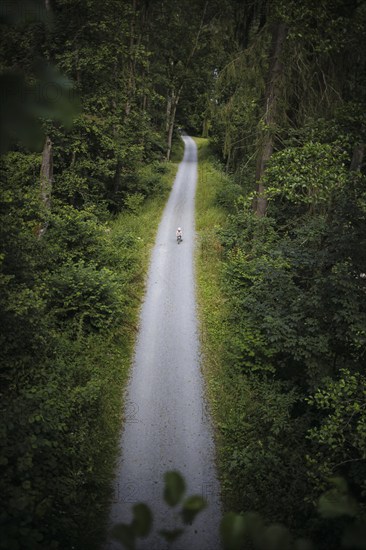 A child on a balance bike rides along a hiking trail through the Höllental valley between Thuringia