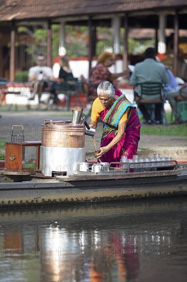 Tealady, 83 years old, making Indian tea on her boat, Backwaters, Kumarakom, Kerala, India, Asia