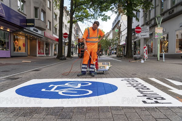 Application of road markings for a cycle lane, Rüttenscheider Straße in Essen, in the shopping and