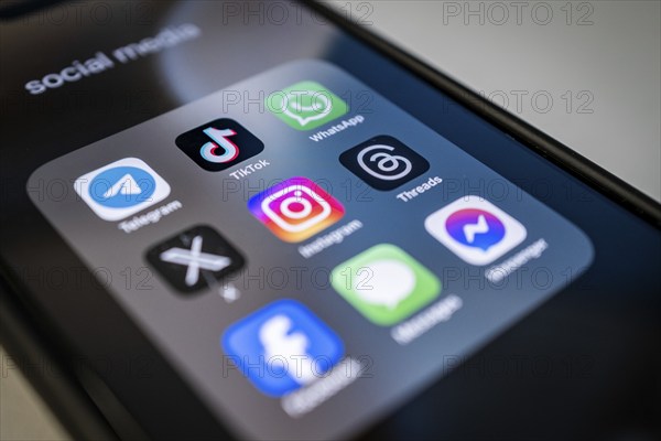 Close-up of a smartphone screen with various social media apps, diffuse light