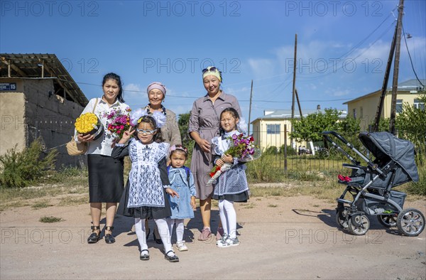 Family and schoolgirl with a bouquet of flowers on the first day of school, Issyk-Kul region,