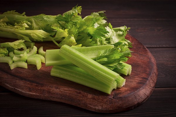 Fresh bunch of celery, top view, no people, on a dark background