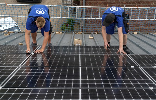 Installation of solar modules on the roof of a barn on a farm, over 240 photovoltaic modules are