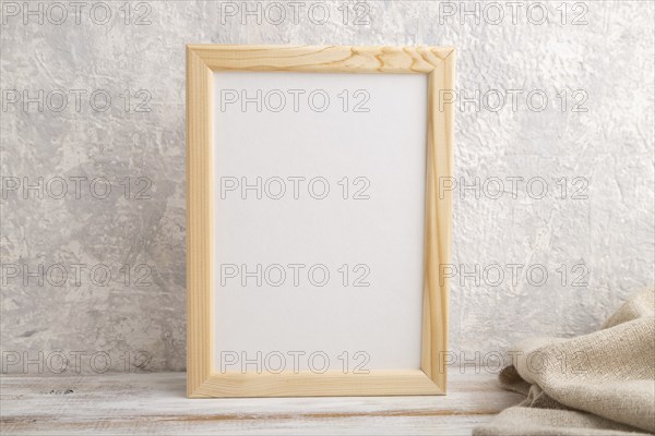 White wooden frame mockup with linen textile on gray concrete background. Blank, vertical
