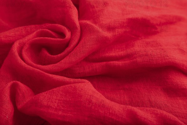 Fragment of red silk tissue. Side view, natural textile background and texture. wave concept,