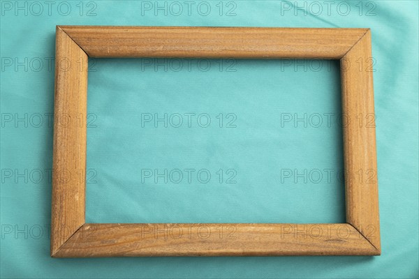 Wooden frame on smooth silk blue tissue. Top view, flat lay, natural textile background and texture
