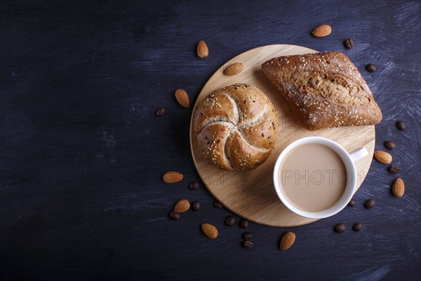 Cup of coffee with cream and buns on a black background. top view, flat lay, copy space