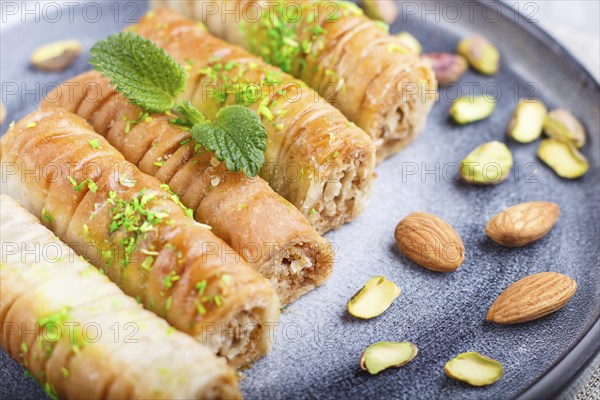 Baklava, traditional arabic sweets in gray ceramic plate on a gray concrete background. side view,