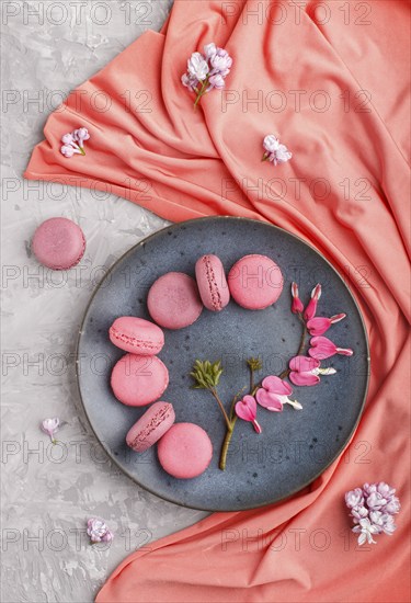 Purple and pink macaron or macaroon cakes with bleeding heart flowers and red textile on blue